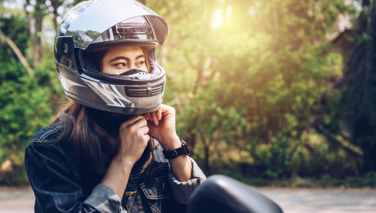 Confidence Asian woman wearing a motorcycle helmet before riding.