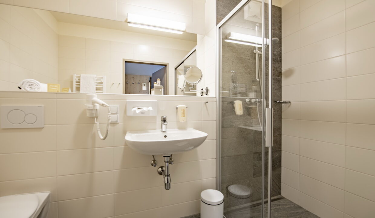 Badezimmer im JUFA Hotel Maria Lankowitz mit Waschbecken und Dusche