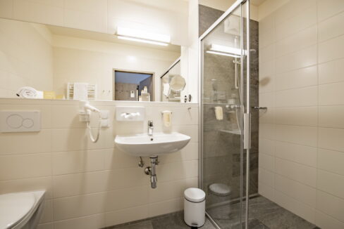 Badezimmer im JUFA Hotel Maria Lankowitz mit Waschbecken und Dusche